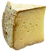 Sweet Grass Dairy | Thomasville Tomme cheese, a semi-soft, natural-rinded cheese with a subtle earthy flavor, showcased in a close-up of its textured surface.