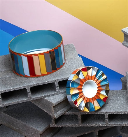 Vista Alegre | Futurismo Catchall Tray displayed on cinder blocks, featuring multicolored, cylindrical and fluted bowls, embodying modern artistic reinvention.