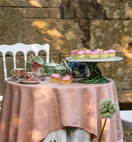 Vista Alegre | The Meaning Espresso Cup and Saucer set with floral design, displayed on a pink tablecloth with cupcakes and a teapot.
