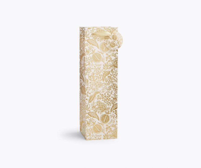 Rifle Paper Co. - Pomegranate Gift Bag: Wine-sized, white with gold botanical pattern, includes round tag, metallic ribbon handles, ideal for gifting wine or specialty bottles.