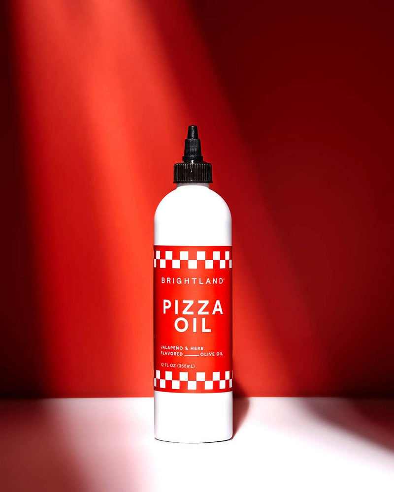 Brightland Pizza Oil, jalapeño and herb-infused olive oil in a sleek bottle, ideal for enhancing pizzas, pasta, and more with a savory kick.