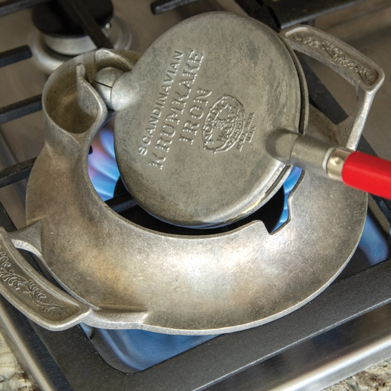 Nordic Ware | Norwegian Krumkake and Pizzelle Iron on stove, featuring detailed press and wooden cone, ideal for crafting traditional Scandinavian and Italian cookies.