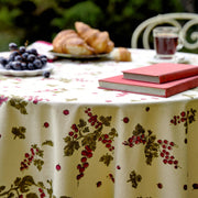 Couleur Nature - Gooseberry Red & Green tablecloth adorns a bistro table with books, coffee, croissants, and grapes, embodying casual elegance and French-inspired design.