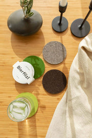 Graf Lantz - Bierfilzl Merino Wool Felt Round Coaster Multi 4 Pack: Forest shown on a table, featuring a glass of water and ice, highlighting its functionality.