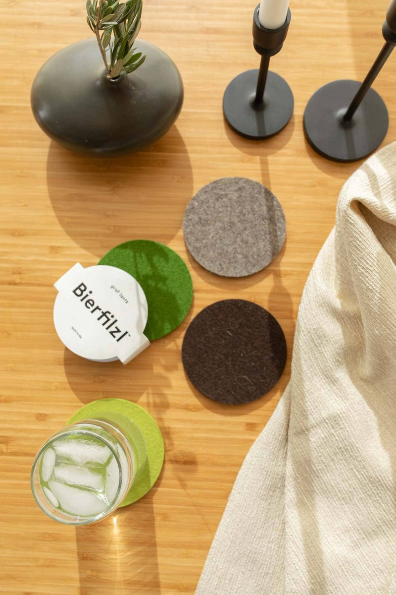 Graf Lantz - Bierfilzl Merino Wool Felt Round Coaster Multi 4 Pack: Forest shown on a table, featuring a glass of water and ice, highlighting its functionality.