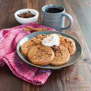 Nordic Ware | Holiday Pancake Pan shown with cookies, coffee, and cinnamon sticks, highlighting festive pancake designs like a tree and star. Perfect for breakfast gatherings.
