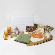 Caravan Home Pumpkin Orange/Mustard Napkins set amidst an autumn-themed tabletop display with amber tumblers, a decorative house box, and a Give Thanks card.