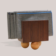 Atelier Saucier | Les Trois Wooden Napkin Holder: A dark walnut tabletop organizer with birch spheres, displaying houndstooth-patterned cloth squares.