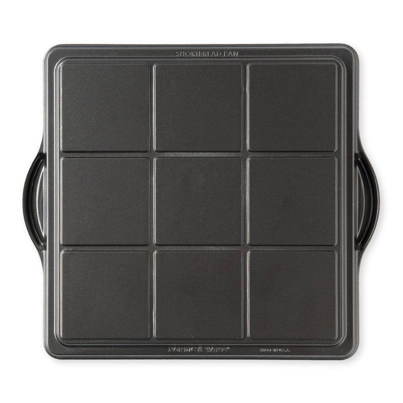 Nordic Ware | English Shortbread Pan, a square black pan with handles, ideal for creating intricate flower and fruit designs in shortbread.