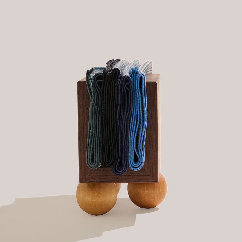 Atelier Saucier | Les Trois Wooden Napkin Holder displayed with socks, showcasing dark walnut wood and birch spheres, embodying mid-century modern style from Athens Cooks.