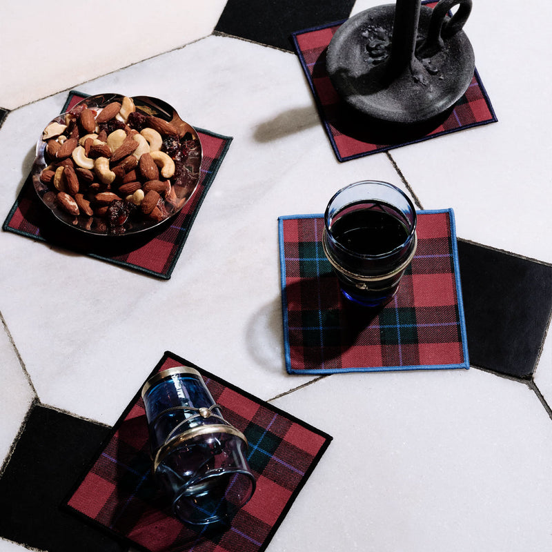 Jubilee Plaid Cocktail Napkins set with mixed nuts, candleholder, and glasses, highlighting festive tableware from Athens Cooks.