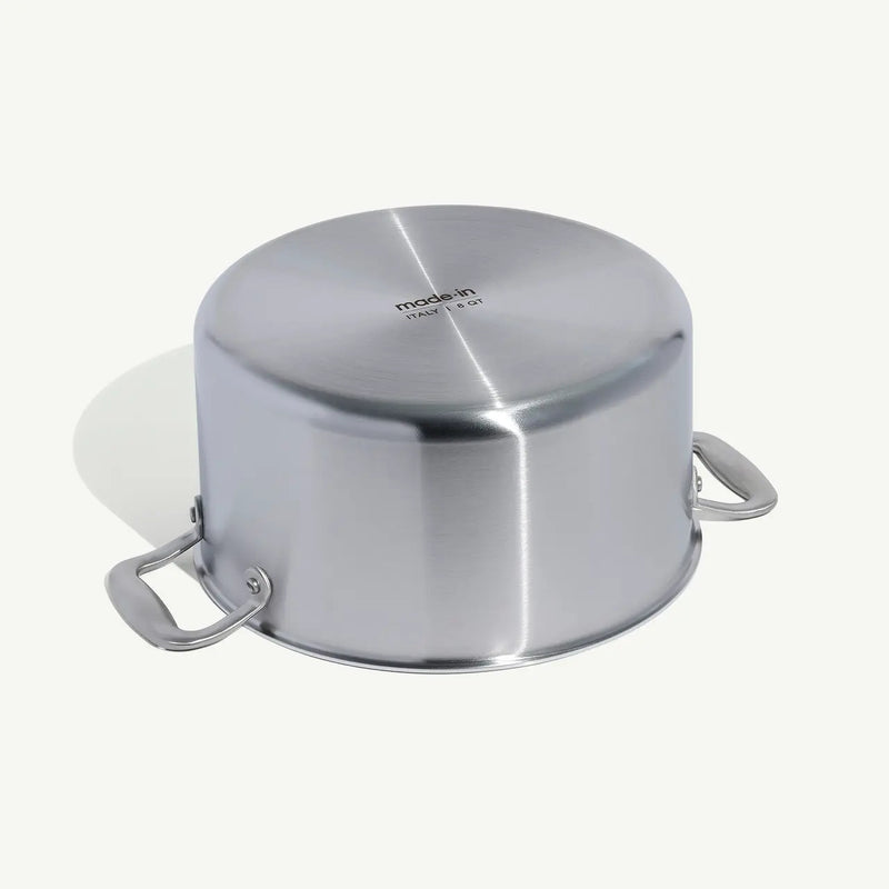 8QT Made In Stainless Steel Stock Pot, viewed upside down, shows base with “Made in Italy” imprint and side handles, highlighting its durable, efficient design.