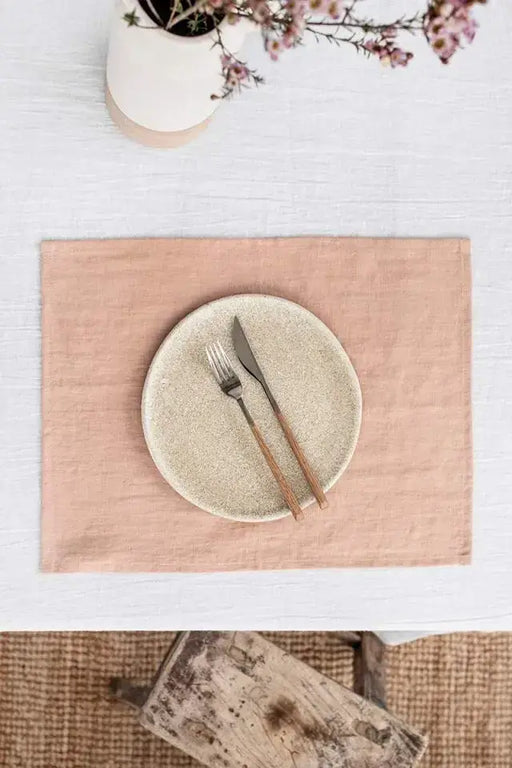 MagicLinen - Peach linen placemat set of 2 displayed on a table with a fork and knife, enhancing dining style and table protection.