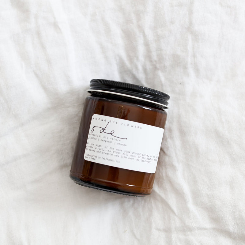 Among the Flowers | Essential Oil + Soy Wax Candle Domes in an amber-glass jar with a black lid, featuring jasmine, bergamot, and orange scents.