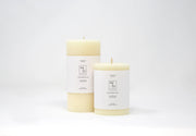 Mo&Co Home - 100% Beeswax Pillar Candles | Natural White: 3x4 Inch. Two hand-poured white candles with labels, showcasing sustainable craftsmanship.