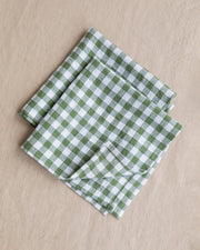 Set of 2 linen napkins in a green and white checkered pattern, folded neatly, showcasing their premium, soft texture and versatile table decor appeal.