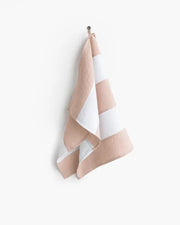 Striped linen tea towel hanging on a hook, showcasing its loop for easy storage; part of MagicLinen's zero-waste collection at Athens Cooks.