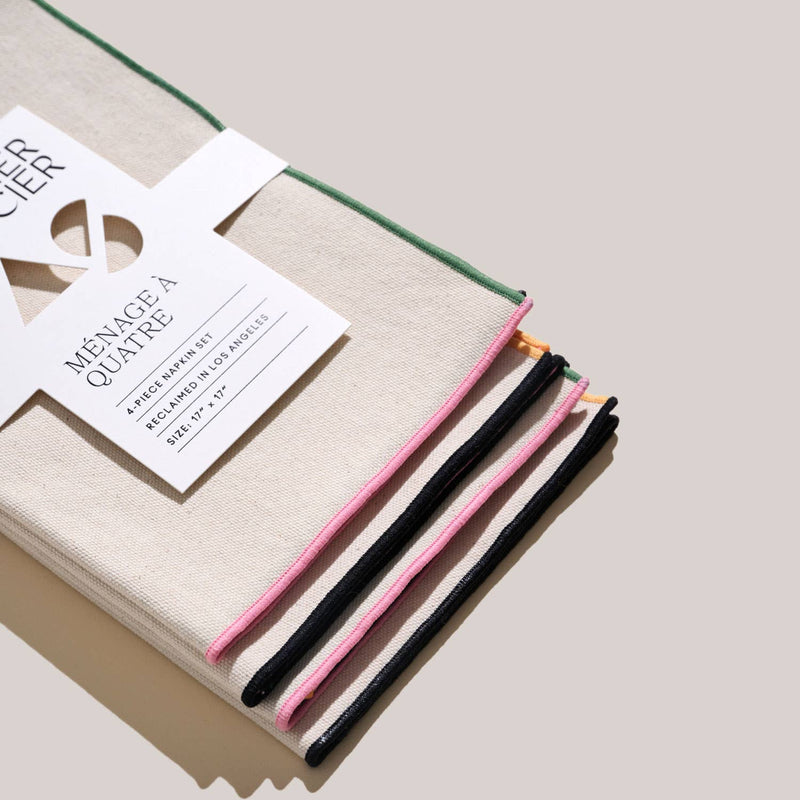 ATELIER SAUCIER - Macaw Burlap Napkins | Set of 4, stacked with a white card, showcasing intricate cut-out designs.