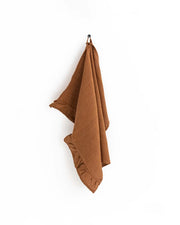 MagicLinen ruffle trim tea towel on a hook, showcasing its soft, absorbent linen fabric and stylish design, ideal for any kitchen setting.