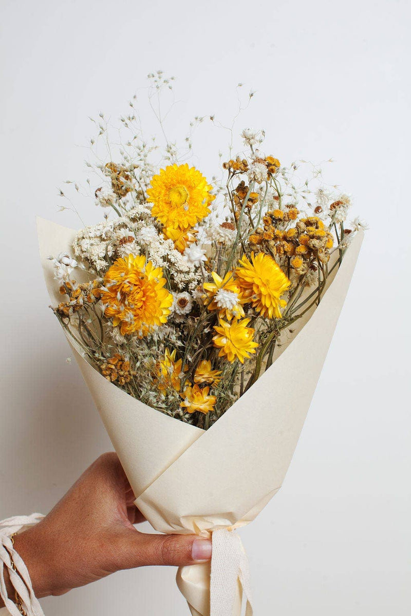 Idlewild Floral Co. - Sunshine Small Field Bouquet featuring bright yellow dried flowers and white fillers in a cream wrap, perfect for spring-themed decor.