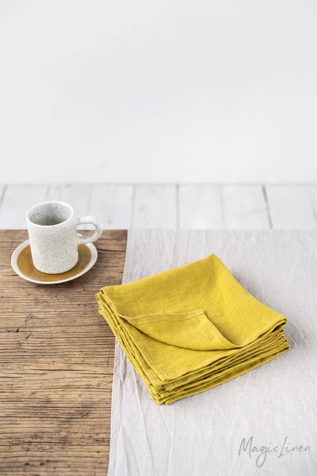 Set of 2 linen napkins stacked on a white tablecloth, ideal for versatile table decor from Athens Cooks. Perfect for sustainable, stylish dining settings.