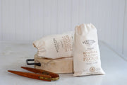 Schermer Pecans - ROASTED AND SALTED PECANS - Ga Grown, displayed in 12 cloth bags on a cutting board, highlighting their fresh, hand-selected quality.