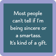 Teal-blue coaster with the phrase “Most people can’t tell if I’m being sincere or a smartass. It’s kind of a gift.” from Drinks on Me.