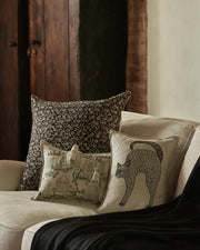 Coral & Tusk - Scaredy Black Cat Pillow: An embroidered cat pillow on an off-white sofa, featuring an arched-back black cat design, perfect for Halloween decor.