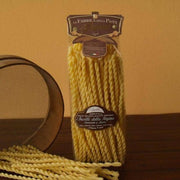 Zia Pia - Fusilli Della Regina by La Fabbrica della Pasta: A clear bag of dried, twisted fusilli pasta with loose strands, perfect for sauces.