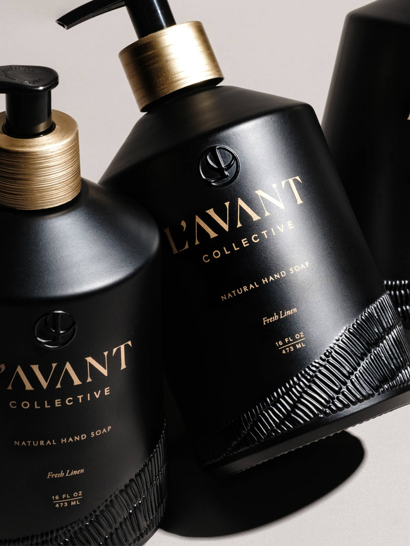 L'AVANT Collective - Fresh Linen Hand Soap in a matte black glass bottle with gold text, offering eco-luxe hand washing with plant-based ingredients.