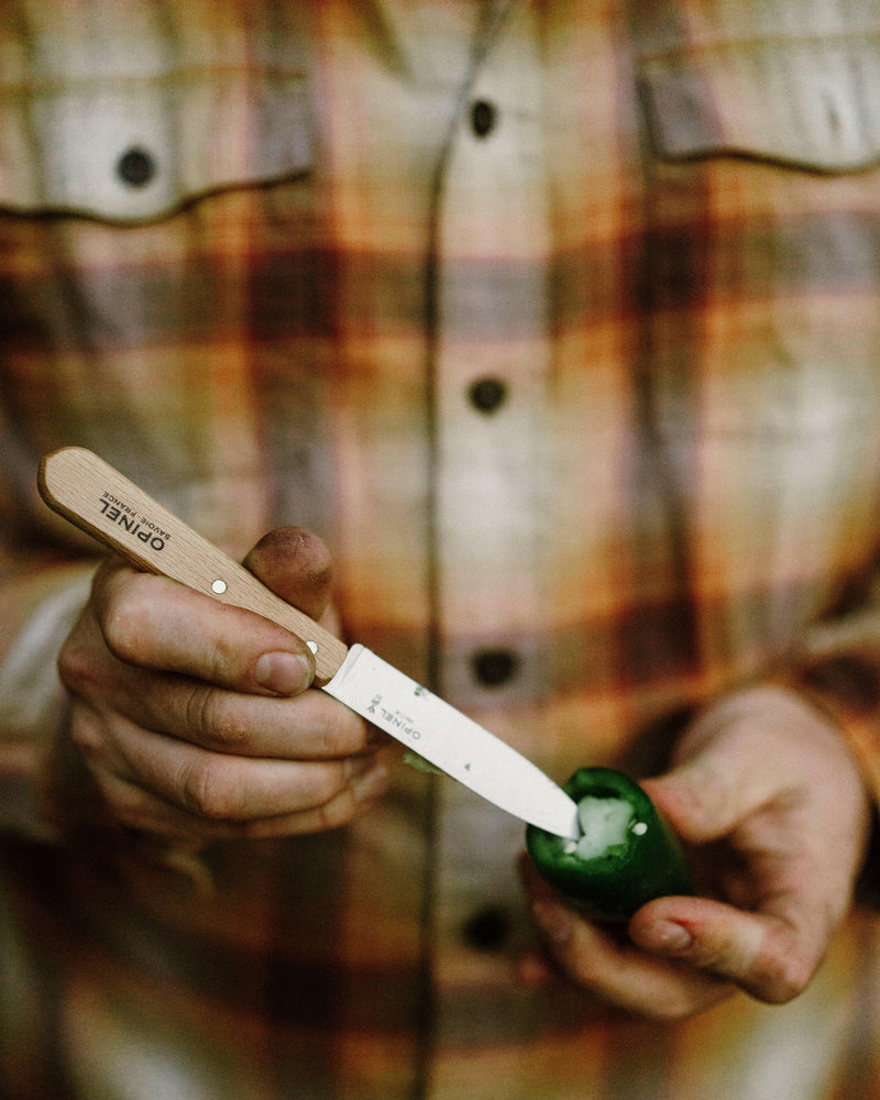 Opinel | No.102 Carbon Paring Knives - Set of 2 shown coring a green pepper, highlighting their precision and craftsmanship, perfect for versatile kitchen tasks.