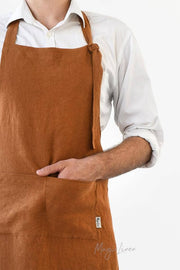 Person wearing a MagicLinen men's linen bib apron with a front pocket and adjustable straps, ideal for grilling and cooking.