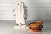 Verve Culture - Italian Olivewood Aperitivo Bowls Set of 4, stacked beside an Alla Cucina canvas pouch. Perfect for serving appetizers, crafted from Umbria's olive wood.