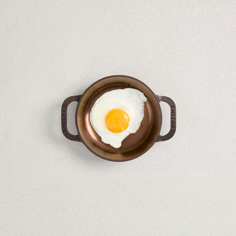 Smithey | No. 6 Dual Handle Skillet with a fried egg, showcasing its cooking capability. Ideal for kitchen enthusiasts from Athens Cooks.