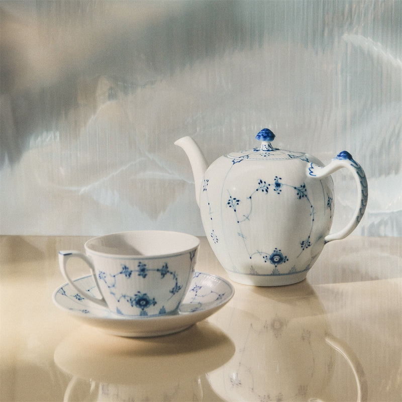 Royal Copenhagen | Blue Fluted Pl Teapot 100cl with intricate blue floral design, featuring a snail shell detail on lid, on light surface.