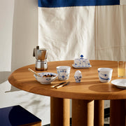 Royal Copenhagen | Blue Fluted Plain Bowl 35cl filled with granola, part of a breakfast set featuring matching porcelain pieces and a Moka pot on a light-oak table.