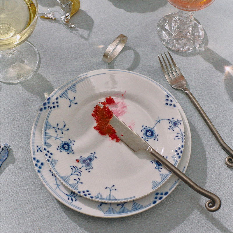 Royal Copenhagen | Blue Elements Plate, 19cm with blue floral pattern, holds fish roe. Set alongside elegant stemware and cutlery, embodying Athens Cooks' curated kitchen elegance.