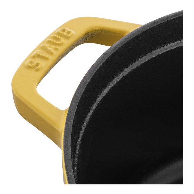 Staub | Round Cocottes - 4 qt Citron features a yellow enameled finish, STAUB handle, and black interior. Ideal for slow-cooking, enhancing Athens Cooks' curated kitchenware.