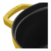 Staub | Round Cocottes - 7 qt Citron: Close-up of yellow enameled cast-iron pot with built-in handle and black interior, ideal for 6-8 servings.