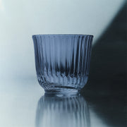 Royal Copenhagen | Waves Water Glass, Blue, Set of 2, featuring ribbed, fluted sides on a reflective surface, embodying both style and practicality for diverse table settings.