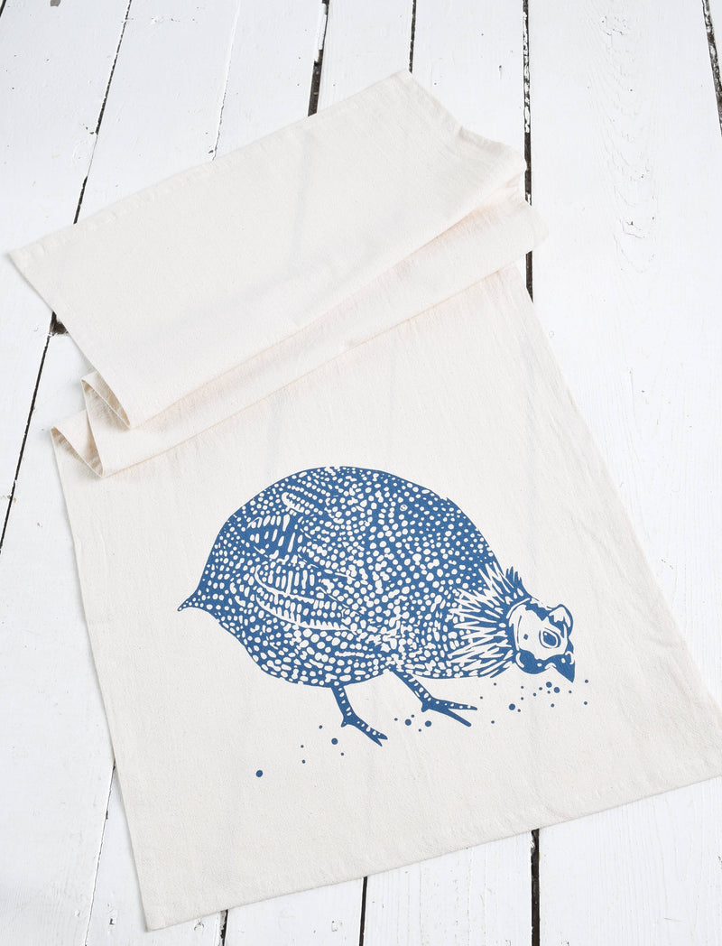 Hearth and Harrow - Organic Cotton Guinea Hen Tea Towel in Navy Blue displayed on a white surface, featuring a screen-printed guinea fowl design, ideal for a stylish kitchen.
