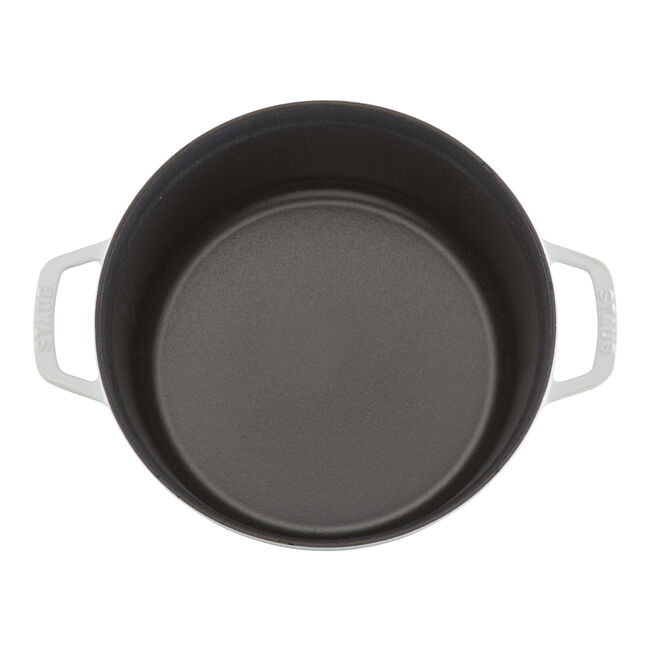 STAUB Round Cocottes - 7 qt White, enameled cast-iron pot with a smooth, dark interior and side handles, ideal for slow-cooking, seen from above.