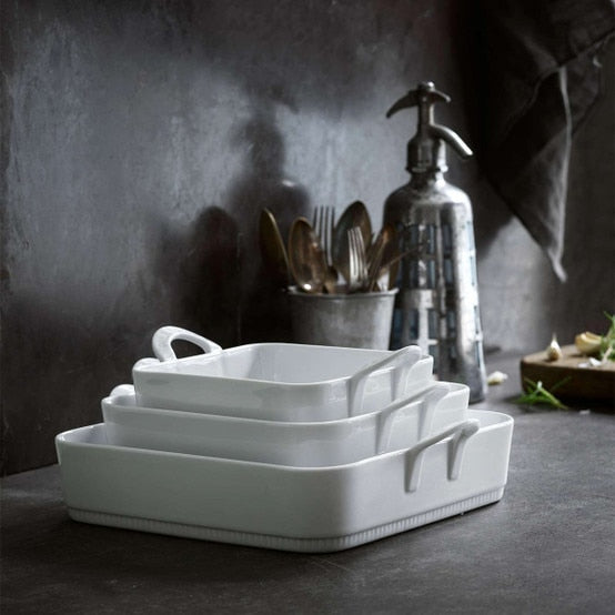 Pillivuyt Toulouse Square Baker - 10.5 showcased in a stack of white ceramic dishes, highlighting its elegant design and durable porcelain craftsmanship.