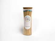 Fredericks & Mae Multi-Colored Fireplace Matches in a cork-stopped glass jar, featuring vibrant match heads and a strike pad on the bottom for easy ignition.