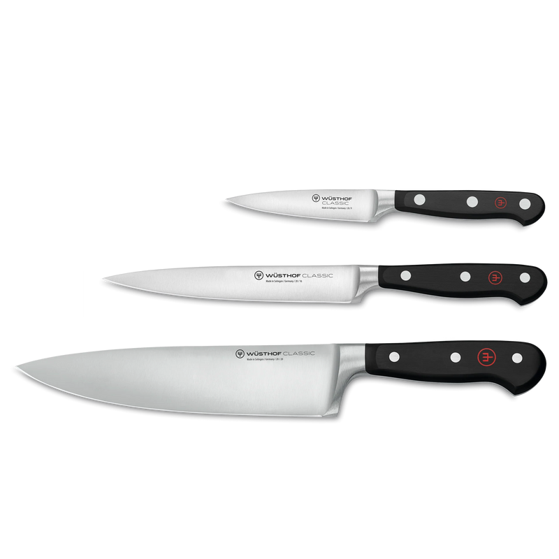 Wüsthof | Three Classic series kitchen knives showcasing paring, utility, and chef’s blades with full-tang, triple-riveted handles, ideal for versatile culinary tasks.