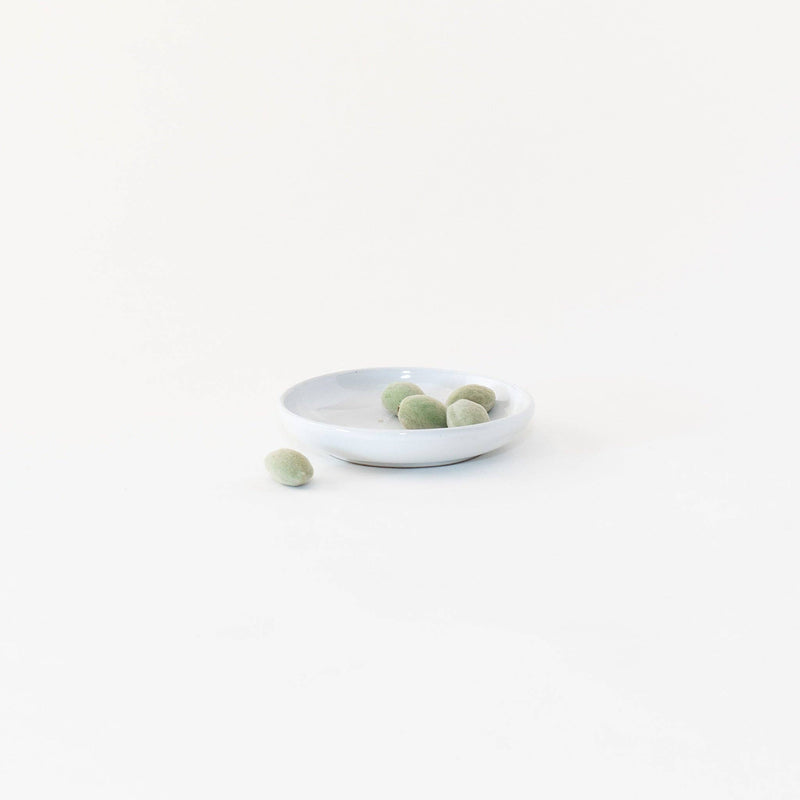 Sarah Kersten - Olive Dish: Basin Collection: Winter Mesa, featuring a small white plate elegantly holding green olives, perfect for versatile use in any kitchen setting.