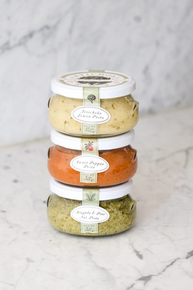 Bella Cucina | Chef's Selection Pesto Trio featuring three jars: Artichoke Lemon, Sweet Pepper, and Arugula Pine Nut Pestos, perfect for versatile culinary applications.