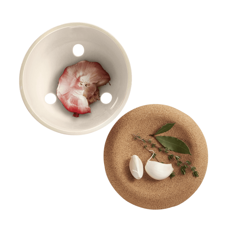 Emile Henry Garlic Pot in Burgundy, showcasing its ventilation design with garlic and herbs, ideal for preserving flavor and adding rustic elegance to kitchens.