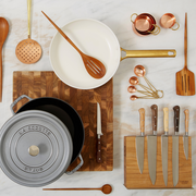 Be Home | Camden Measuring Spoons displayed with kitchen utensils and a pan on a cutting board, highlighting handcrafted copper craftsmanship.