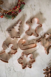 Galley and Fen - Christmas Cookie Cutters - Set of 6 on marble, featuring festive shapes like tree, gingerbread, snowflake, with wreath and pinecone accents.